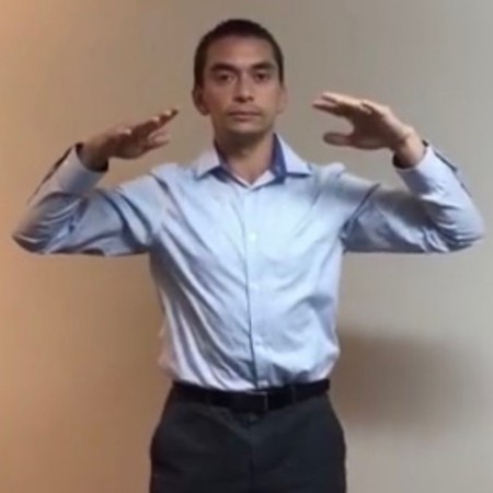 In this qigong pose, arms are at neck height and hands point inwards towards each other.